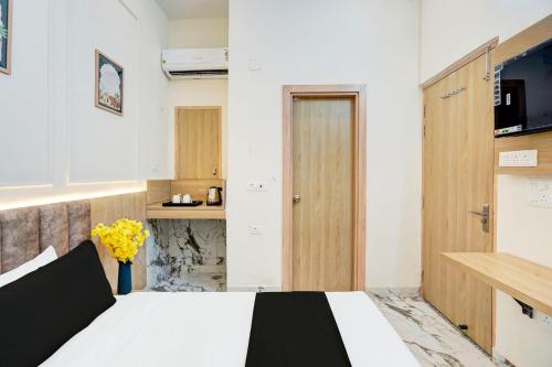 a bedroom with a bed and a kitchen at Super Collection O Surajpur Chowk Greater Noida in Noida