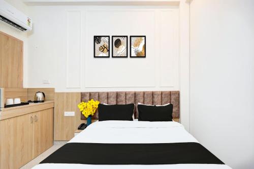 a bedroom with a bed and three pictures on the wall at Super Collection O Surajpur Chowk Greater Noida in Noida