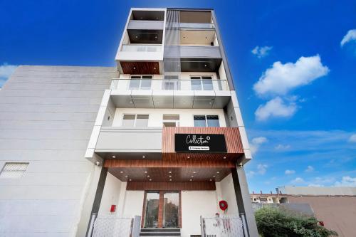 a tall white building with a sign on it at Super Collection O Surajpur Chowk Greater Noida in Noida