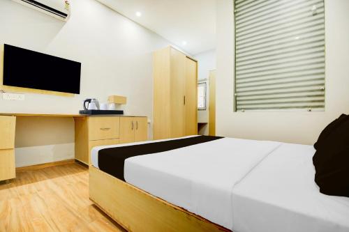 a bedroom with a white bed and a television at Super Collection O Phagwara Near LPU Law Gate in Phagwāra