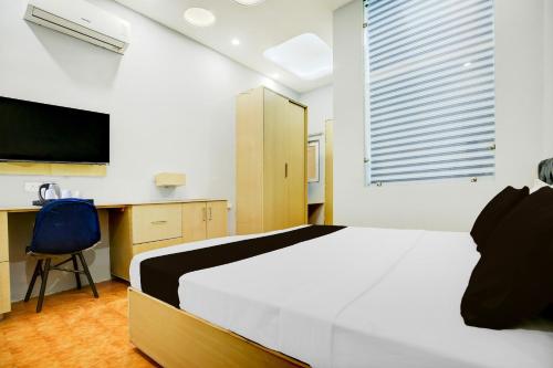 a bedroom with a bed and a desk and a tv at Super Collection O Phagwara Near LPU Law Gate in Phagwāra