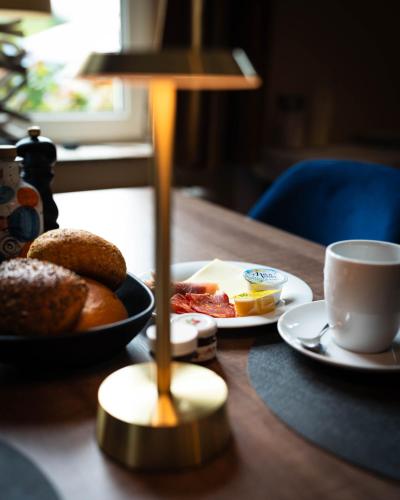 a table with plates of food and a cup of coffee at Hotel Villa Tripaldi in Schönberg in Holstein