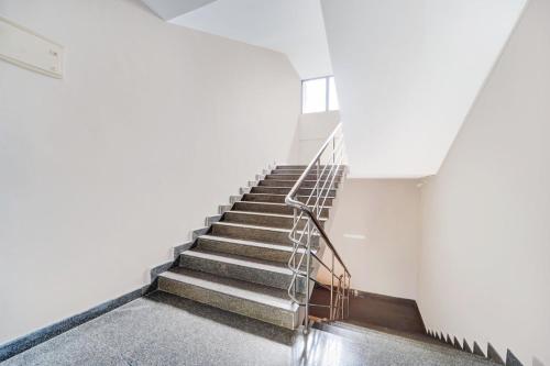 a staircase in a building with a metal railing at Super Hotel O Sultan Bathery formerly Bluevalley in Wayanad