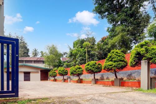 a row of trees in front of a wall at Super Hotel O Sultan Bathery formerly Bluevalley in Wayanad