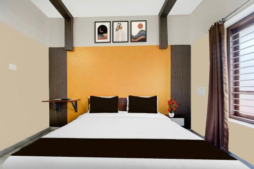 a bedroom with a large bed with a yellow wall at Super Hotel O Kazhakkoottam Near Technopark Phase 3 in Trivandrum