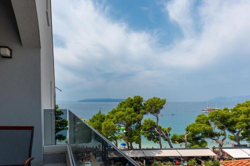 a view of the ocean from a balcony of a building at Hotel Central Beach 9 in Makarska