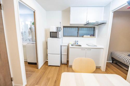 a small kitchen with a sink and a refrigerator at Hiro Yanaka hotel TT0421 in Tokyo