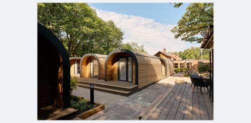 a house with a wooden exterior with a patio at Moddershall Oaks Country Spa Retreat in Stone