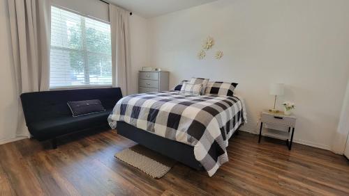 a bedroom with a bed and a chair and a window at Spacious 2BR 2BA Suite - Walk to Mall & Hospitals in Gainesville