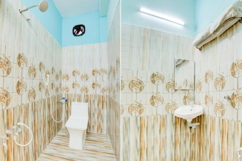 a bathroom with a toilet and a sink at Hotel O Walajapeti Vellore in Wālājāpet