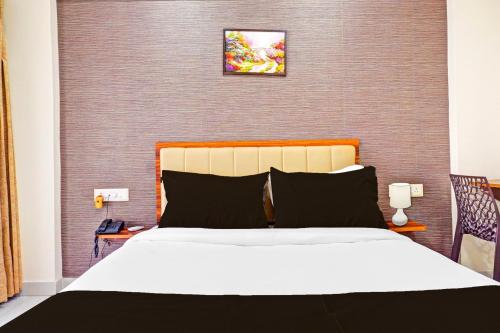 a bedroom with a large bed and a wall at Super Townhouse Amanora Park Town Formerly Samrat Inn in Pune