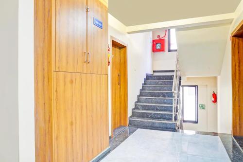 a hallway with a staircase and a wooden door at Super Townhouse Amanora Park Town Formerly Samrat Inn in Pune