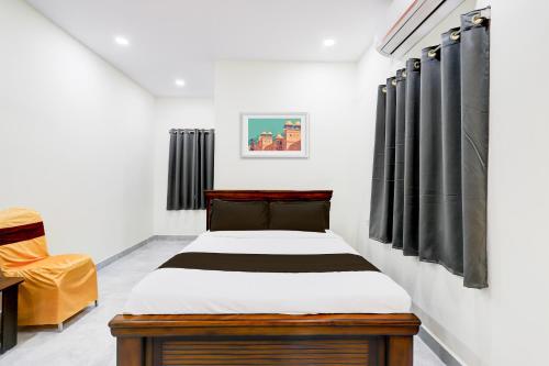 a bedroom with a bed and a chair at Super Collection O Vanasthalipuram in Hyderabad