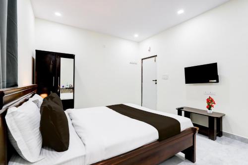 a bedroom with a large bed and a television at Super Collection O Vanasthalipuram in Hyderabad