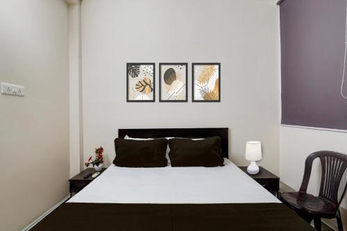 a bedroom with a bed with four pictures on the wall at Super Hotel O Janappanchatram in Chennai