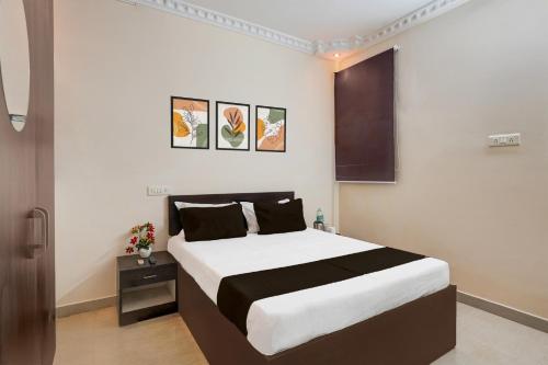 a bedroom with a large bed and three paintings on the wall at Super Hotel O Janappanchatram in Chennai