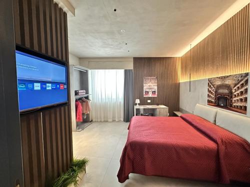 a bedroom with a red bed and a flat screen tv at Zen escape Sicilia in San Gregorio di Catania