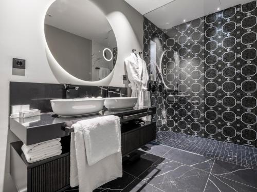 a bathroom with a sink and a mirror at Steigenberger Icon Europäischer Hof Baden Baden in Baden-Baden