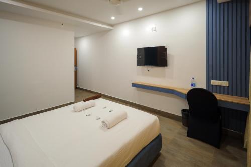 a hospital room with a bed and a flat screen tv at Hotel Heraa Boarding Lodging in Mangalore