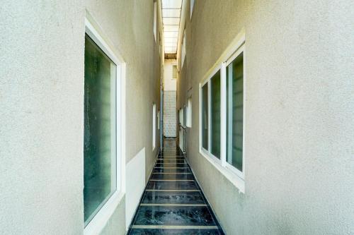 an empty hallway with tiled floors and windows at Super Collection O Charing Cross Ooty in Ooty