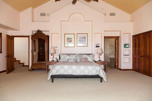 a large bedroom with a bed and two tables at Mango Sunsets in Kawaihae