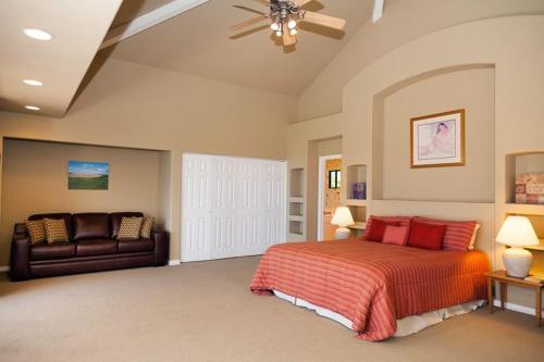 a large bedroom with a bed and a couch at Mango Sunsets in Kawaihae
