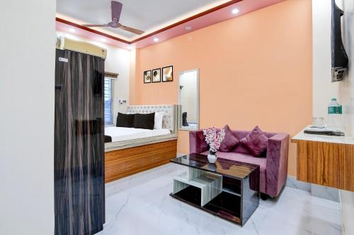 a living room with a purple couch and a bed at Super Hotel O Kakdwip in Kākdwīp