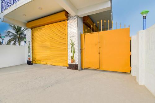 a garage with yellow doors on a building at Super Hotel O Kakdwip in Kākdwīp