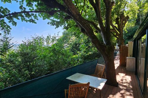 a table and two chairs on a porch with a tree at Beautiful loft for 2 with lovely terrace in a quiet location 
