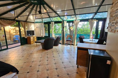 a living room with a large room with windows at Beautiful loft for 2 with lovely terrace in a quiet location 