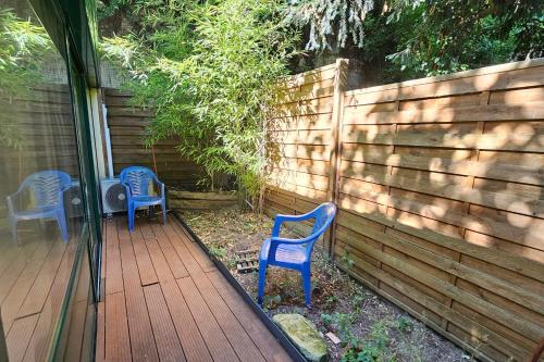 two blue chairs sitting on a deck next to a fence at Beautiful loft for 2 with lovely terrace in a quiet location 