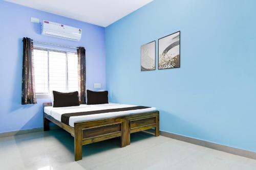a blue bedroom with a bed in a room at Hotel O Durgapur Near NSHM College Formerly MON Palace in Mālandighi