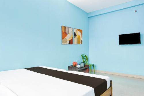 a bedroom with a bed and a blue wall at Hotel O Durgapur Near NSHM College Formerly MON Palace in Mālandighi