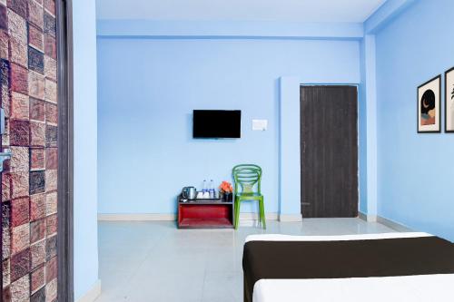 a room with a bed and a tv and a chair at Hotel O Durgapur Near NSHM College Formerly MON Palace in Mālandighi
