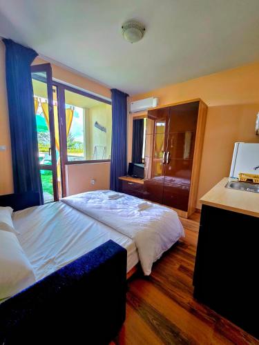 a bedroom with a large bed and a window at Апартамент- Студио Кокетно in Sandanski