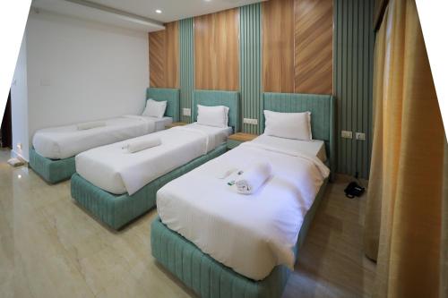 a room with three beds in a room at Hotel Heraa Boarding Lodging in Mangalore