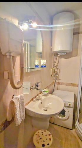 a bathroom with a white toilet and a sink at Апартамент- Студио Кокетно in Sandanski