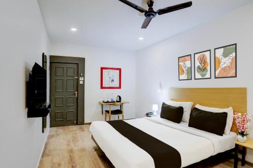 a bedroom with a large bed and a television at Super Townhouse Kalmana in Nagpur