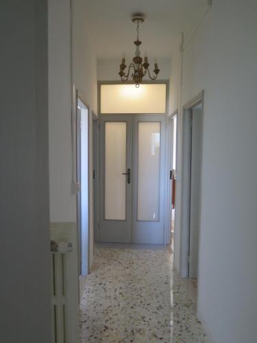 a hallway with a door and a chandelier at Orologio a Cucù in Montecarotto