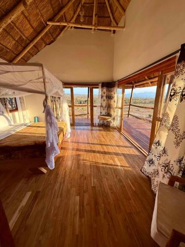 a bedroom with a bed and a wooden floor at Camp Lilac Mikumi in Mikumi National Park