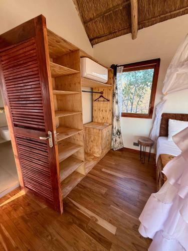 a small room with a bed and a closet at Camp Lilac Mikumi in Mikumi National Park