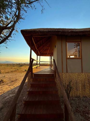 a staircase leading to a house with a roof at Camp Lilac Mikumi in Mikumi National Park