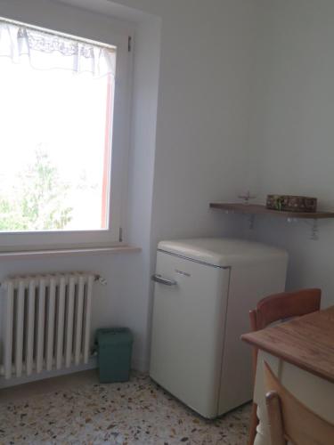 a small white refrigerator in a room with a window at Orologio a Cucù in Montecarotto