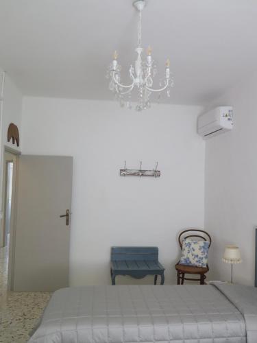 a bedroom with a bed and a chandelier at Orologio a Cucù in Montecarotto