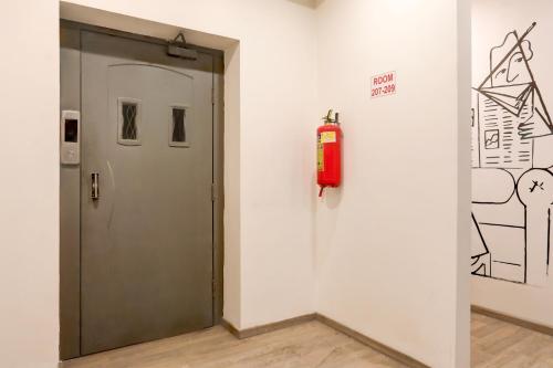 a fire extinguisher on a wall next to a door at Super Townhouse Kalmana in Nagpur