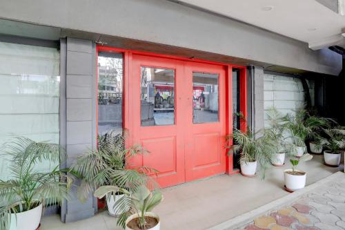 a red door on a building with potted plants at Super Townhouse Kalmana in Nagpur