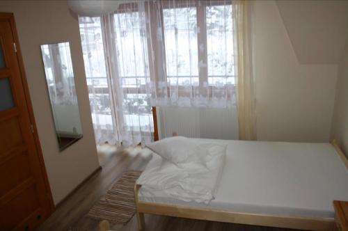 a bedroom with a bed and a large window at Noclegi KLARA in Zawoja