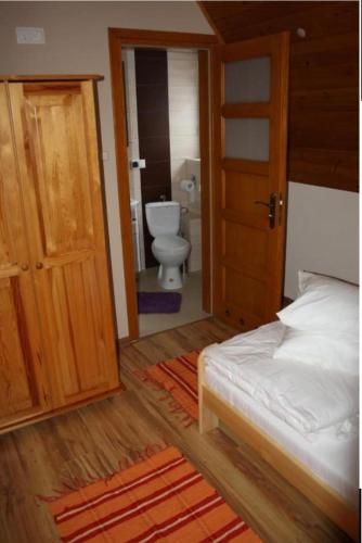 a bedroom with a bed and a bathroom with a toilet at Noclegi KLARA in Zawoja