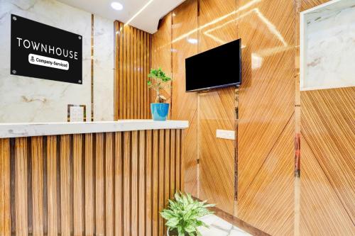 a lobby with a tv on a wooden wall at Super Townhouse Rajahmundry in Rājahmundry