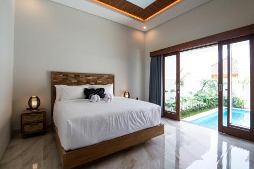 a bedroom with a bed and a large window at Villa Sakura ll seminyak in Seminyak